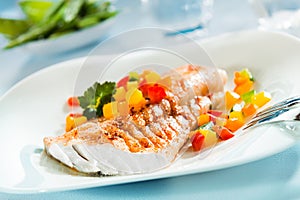 Grilled fish fillet with a colorful fresh salad