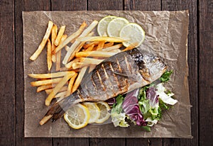 Grilled fish with french fries and salad