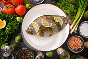 Grilled fish with fresh vegetables, on a wooden black background. I also eat healthy food. Seafood, Eastern or European cuisine