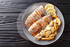 Grilled fish mackerel fillet with a side dish of fried potatoes close-up on a plate. Horizontal top view