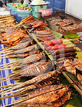 Grilled fish and meat skewers sold in an Asian food street market