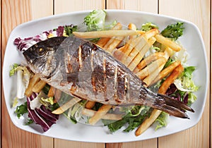 Grilled fish with salad and french fries