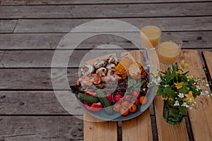 Grilled fish and shrimp with vegetables on the picnic table