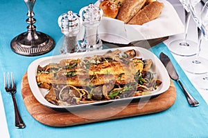 Grilled fish steak with mushrooms, oyster mushrooms, boletus, greens and onion rings.