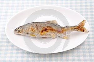 Grilled fish sweetfish with salt Japanese dish ayu no shioyaki on plate on table