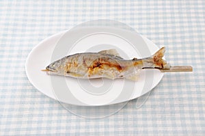 Grilled fish sweetfish with salt Japanese dish ayu no shioyaki on plate on table
