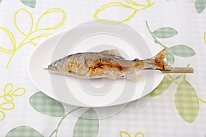 Grilled fish sweetfish with salt Japanese dish ayu no shioyaki on plate on table