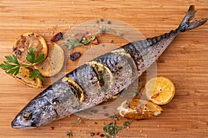 Grilled fish and various vegetables on a chopping board