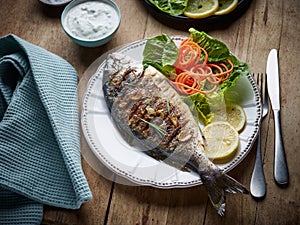 Grilled fish on wooden kitchen table