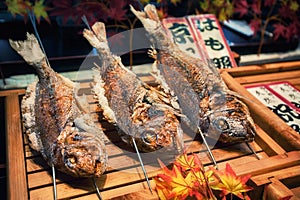 Grilled fishes on sticks as street food at Nishiki market, Kyoto, Japan