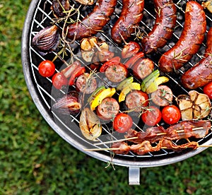 Grilled food. Various grilled products: Grilled sausages, meat and vegetable skewers, bacon and vegetables on the grill plate, out