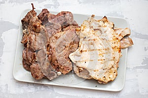 grilled fresh meat on big gray dish on ceramic