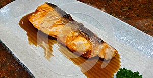 Grilled fresh salmon with Teriyaki sauce on white plate or dish at Japanese restaurant. Top view of Asian or fish food.