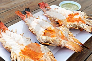 Grilled giant river shrimp or prawn with spicy seafood on wooden table at resturant in  Thailand