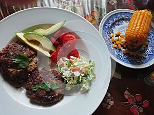 Grilled grassfed organic hamburgers with coldslaw and avocado chef plate