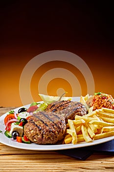 Grilled Greek bifteki with salad and French fries