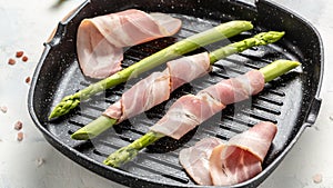 Grilled green asparagus wrapped with bacon on a grill pan, Food recipe background. Close up