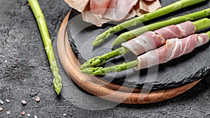 Grilled green asparagus wrapped with bacon on a grill pan, Food recipe background. Close up