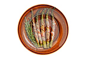 Grilled green asparagus wrapped with bacon on a plate. Isolated, white background. Top view.