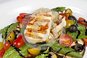 Grilled Halloumi Cheese poured with garlic olive oil salad witch grilled eggplant, cherry tomatoes, black olives and spinach