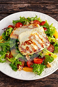 Grilled Halloumi Cheese salad witch orange, tomatoes and lettuce. healthy food