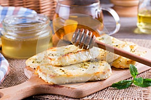 Grilled haloumi cheese with herbs on a cutting board
