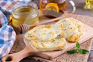 Grilled haloumi cheese with herbs on a cutting board