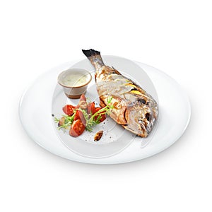 Grilled healthy dorado fish with vegetables on a round plate