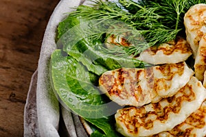 Grilled homemade halumi cheese with fresh green herbs