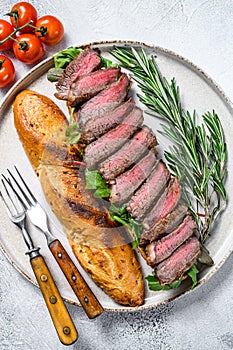 Grilled Homemade rib eye Steak sandwich with sliced roast beef, arugula. White background. Top view