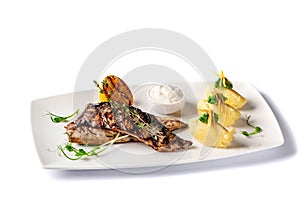 Grilled juicy mackerel, served with mashed potatoes, lemon, and tartar sauce. Microgreen. Modern pitch on a white tarekle