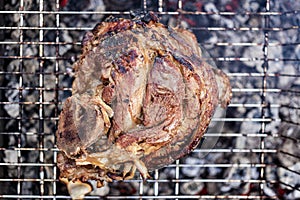 Grilled juicy pork knuckle. Appetizing knuckle or boar hoof. Cooking pork leg on coals. Close-up