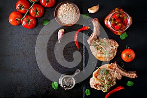 Grilled juicy steak on the bone with vegetables on a dark background.