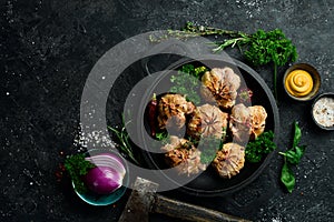 Grilled Juicy Turkey Cutlets. In a pan with spices and herbs. On a black stone background.