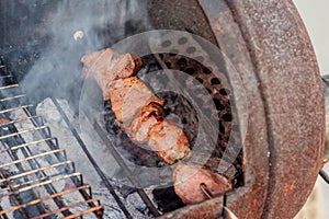 Grilled kebab cooking on metal skewer closeup. Roasted meat cooked at barbecue. BBQ fresh beef meat chop slices