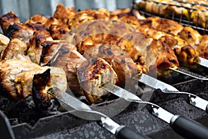 Grilled kebab cooking on metal skewer closeup. Roasted meat cooked at barbecue. Traditional eastern dish, shish kebab. Grill on ch