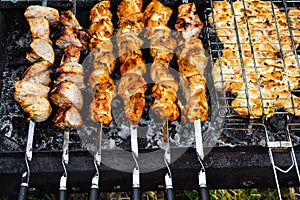 Grilled kebab cooking on metal skewer closeup. Roasted meat cooked at barbecue. Traditional eastern dish, shish kebab. Grill on ch