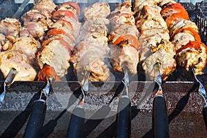 Grilled kebab cooking on metal skewer closeup. Roasted meat cooked at barbecue. Traditional eastern dish, shish kebab. Grill on ch
