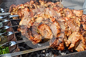 Grilled kebab cooking on metal skewer closeup. Roasted meat cooked at barbecue. Traditional eastern dish, shish kebab. Grill on ch