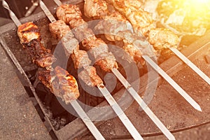 Grilled kebab cooking on metal skewer. Roasted meat cooked at barbecue. BBQ fresh beef meat chop slices. Traditional eastern dish,
