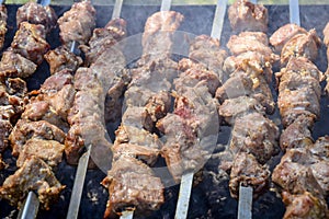 Grilled kebab cooking on metal skewer. Roasted meat cooked at barbecue. BBQ fresh pork meat chop slices. Eastern dish, shish kebab
