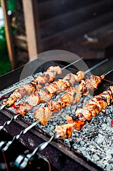 Grilled kebab cooking on metal skewer. Roasted meat cooked at barbecue. Traditional eastern dish, shish kebab. Grill on