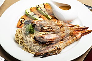 Grilled King prawns or shrimps with noodles and grilled veggies and sauce