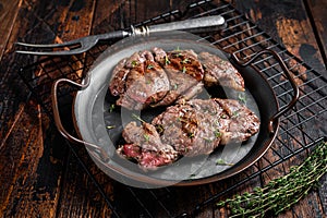 Grilled Lamb chop leg steaks, mutton meat with herbs. Wooden background. Top view