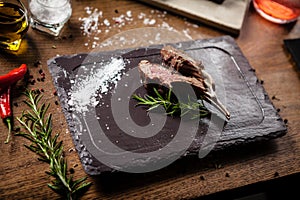 Grilled lamb chops served with a branch of rosemary