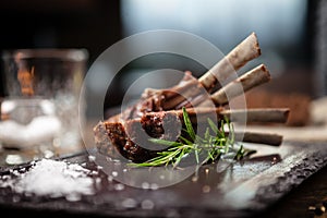 Grilled lamb chops served with a branch of rosemary