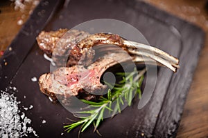 Grilled lamb chops served with a branch of rosemary