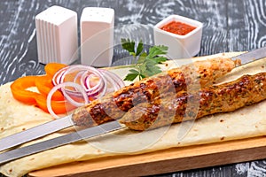 grilled lamb kebab with vegetables on lavas in restaurant serving