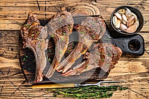 Grilled lamb mutton meat chops steaks on a cutting board. wooden background. Top view