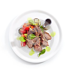 Grilled Lamb Rack with Baked Vegetables on White Restaurant Plate Top View